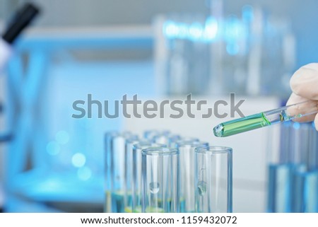 Analyst dripping reagent into test tube with sample at laboratory, closeup. Chemical analysis