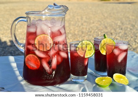 pitcher and glasses of hibiscus flower iced tea in Mojave Desert setting Royalty-Free Stock Photo #1159458031
