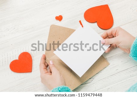 Hand of girl writing love letter on Saint Valentines Day. Handmade postcard with red heart shaped figure. 14 February holiday celebration. Valentine day concept with copy space. Royalty-Free Stock Photo #1159479448