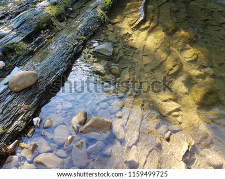 Rocks underwater on riverbed with clear fresh water