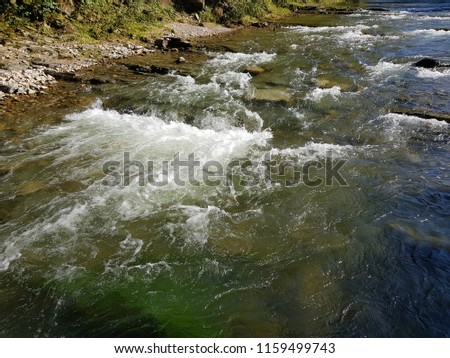 Rocks underwater on riverbed with clear fresh water