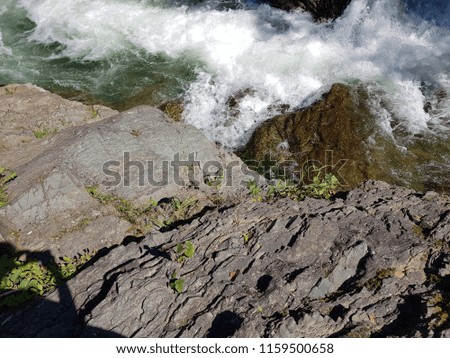 Big rocks on waves with mountains