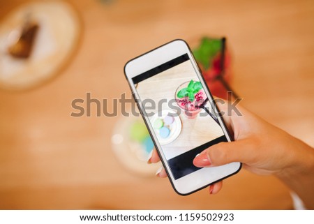 Young woman blogger is making mobile food photo. Concept content for instagram