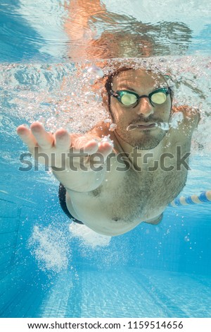 Male swimmer in the swimming pool.Underwater photo with copy space.
