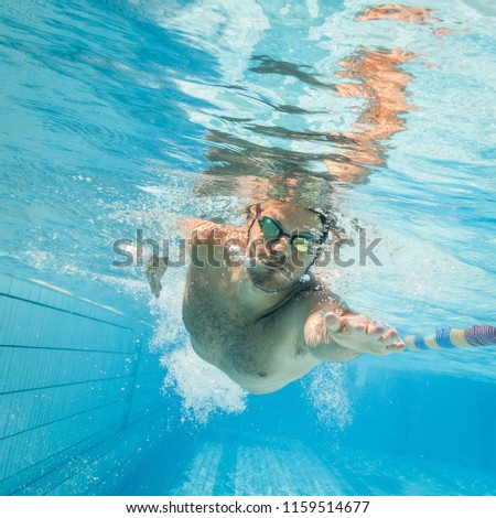 Male swimmer in the swimming pool.Underwater photo with copy space.