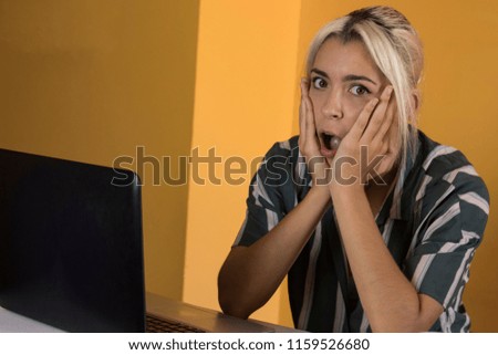 Surprised office worker reading good news on a computer