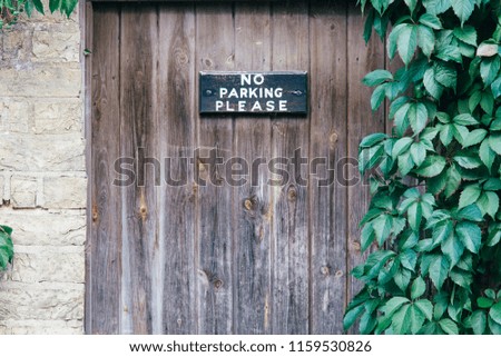 No parking sign in front of the wooden fence