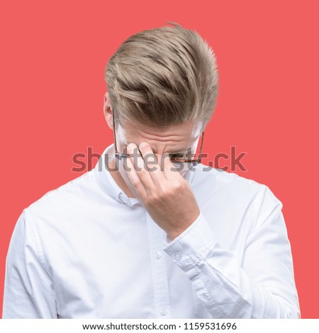 Young handsome blond man tired rubbing nose and eyes feeling fatigue and headache. Stress and frustration concept.