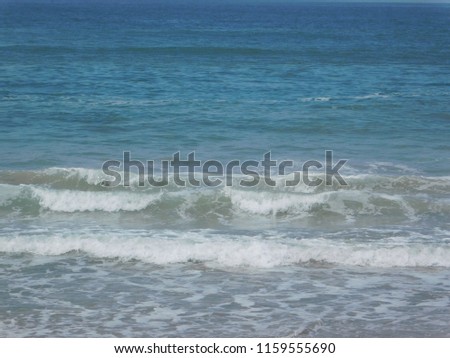 White Foamy Ocean Waves Rolling Quickly Onto the Brown Beach Sea Shore on a Summer Day
