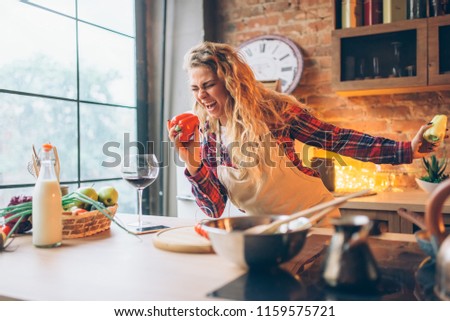 Housewife in an apron plays with fresh pepper