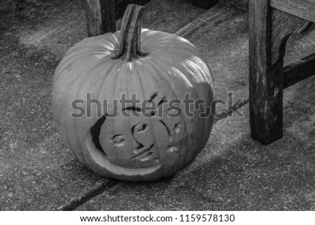 A sun and moon carved Jack o lantern in black and white