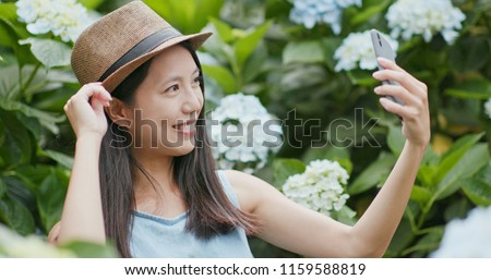 Woman taking selfie on cellphone in Hydrangea farm