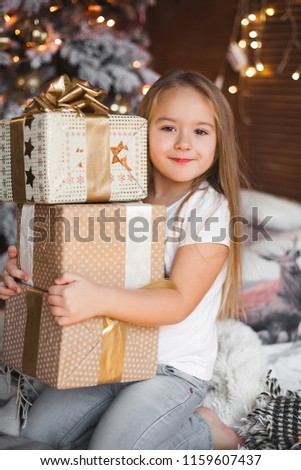 Cute little child holding christmas presents
