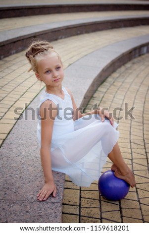 girl gymnast in the white dress of gymnastic ball