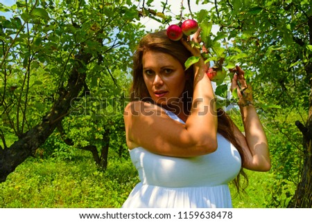 Portrait of fat woman in white in Apple garden
