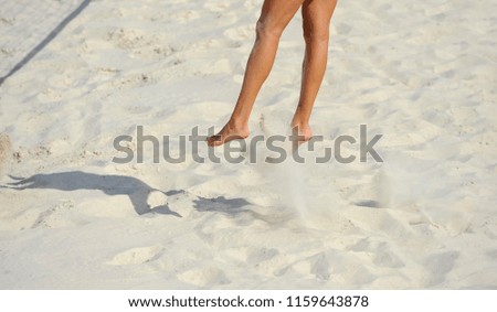 Close-up of feet and legs of a female beach volleyball player