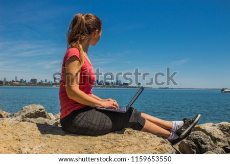 Freelancer woman working on the lake shore, Toronto, Canada