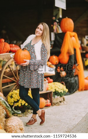 Autumn portrait of young happy woman on farm market