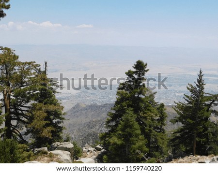 Looking Down from Desert Mountains into a Valley with Towns and Cities Scattered in the Distance on a Hot Summer Day
