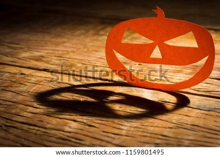 Halloween background decoration holiday concept. Jack O pumpkin smiling face shadow and silhouette on wooden table