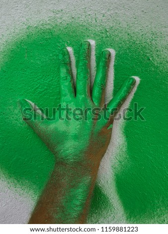Hand a cliche a green paintHand a cliche a green paint on a wall