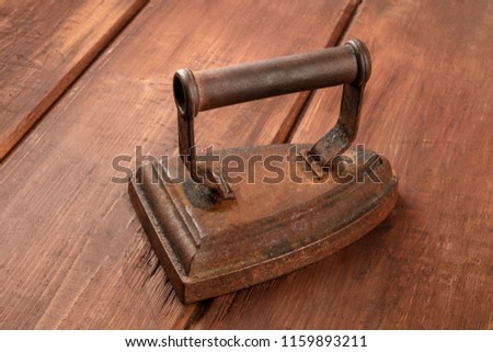 A photo of a vintage iron on a dark rustic background with copyspace