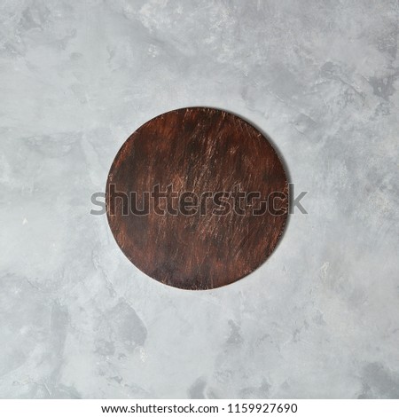 The central composition with brown wooden board on a gray concrete background, can be used for display or montage your products