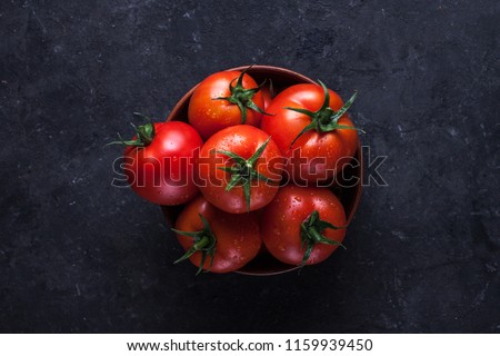 Red, ripe tomatoes on a dark background. Harvesting tomatoes. Top view Royalty-Free Stock Photo #1159939450