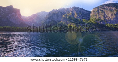 lake and mountain landscape with lens flare effect added from sun