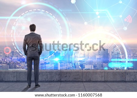 Rear view of businessman standing on balcony looking at futuristic glowing icons. Abstract HUD and infograph in city sky. Toned image double exposure mock up Elements of this image furnished by NASA