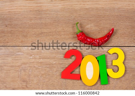 2013 New Year color date and red chili pepper on oak wood textured background