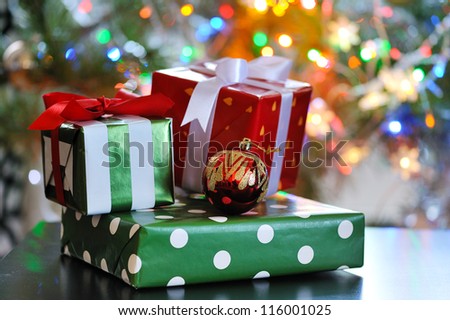 festive gift boxes against glowing christmas tree