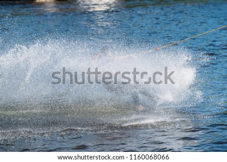 Surfer slipping on a board covered by splashed water In the Trzesiecko lake in Szczecinek.