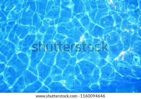 Water surface in swimming pool. Sun reflection on water