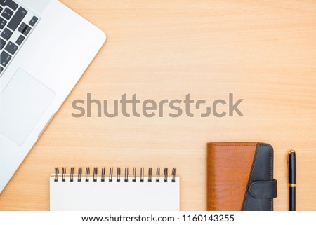 Flat lay photography. Laptop, empty white notebook page, diary agenda and a pen on a wooden table. Write memo office idea concept.