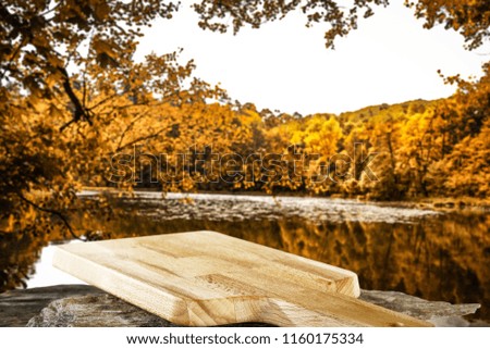 Desk of free space and autumn background with lake landscape. 