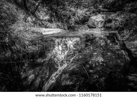 Mountain panorama with waterfall in summer in black and white