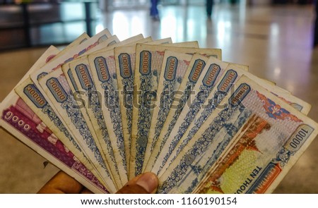 Hand holding Myanmar banknotes (MM, MMR, Kyat). Currency background.