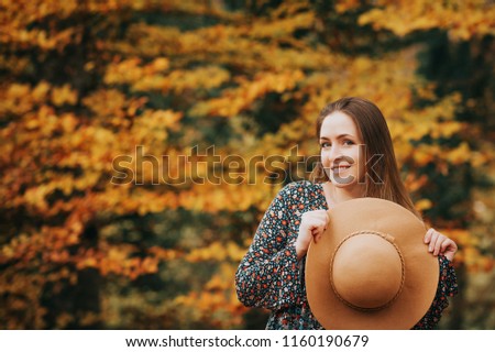 Outdoor portrait of beautiful woman enjoying autumn forest on a nice warm day