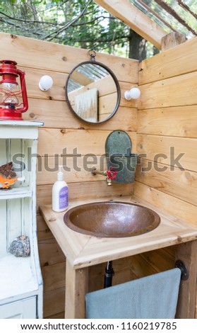 An outdoor shower and composting toilet stall at a glamping site