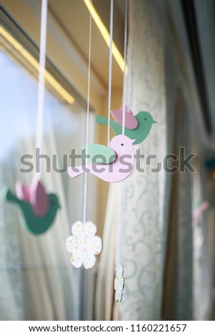 decor in the form of wooden birds in pink. Birds have peppermint wings. They are suspended on a satin ribbon

