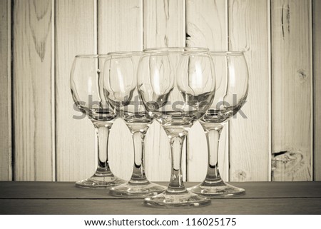 Empty wine glass on table in front of wood vintage background