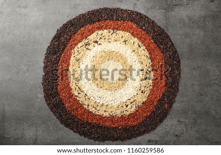 Composition with different types of rice on grey background