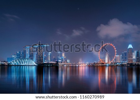 Downtown Singapore city in Marina Bay area with reflection. Financial district and skyscraper buildings at night.