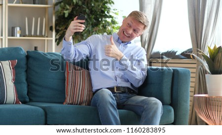 Man Taking Selfie while Sitting on Couch, Photograph