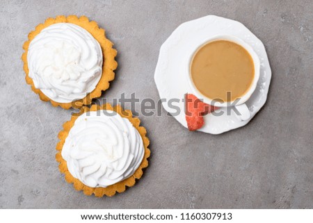 Delicious Dessert. Lemon tartlet tart with meringue and cup of hot coffee, watermelon heart on grey stone concrete table background.