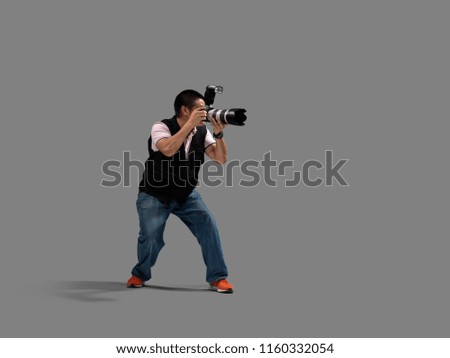 Portrait of male photographer with cameras isolated on grey background