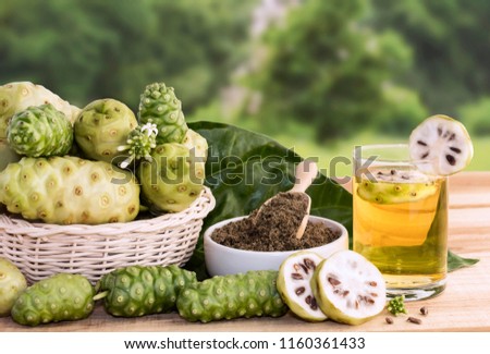 Noni fruit juice or Morinda Citrifolia with noni slice and noni powder for health on the wooden background with copy space for text. Royalty-Free Stock Photo #1160361433