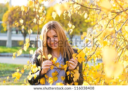 close up portrait of autumn woman with yellow leaves