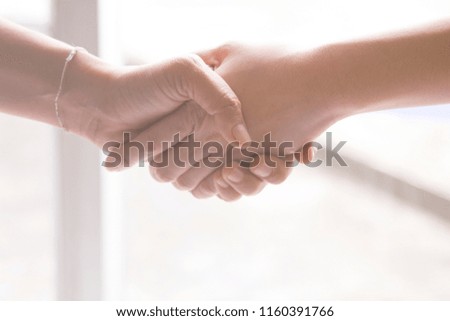 two hands holding together represents cooperation of people leading to success with white background Royalty-Free Stock Photo #1160391766